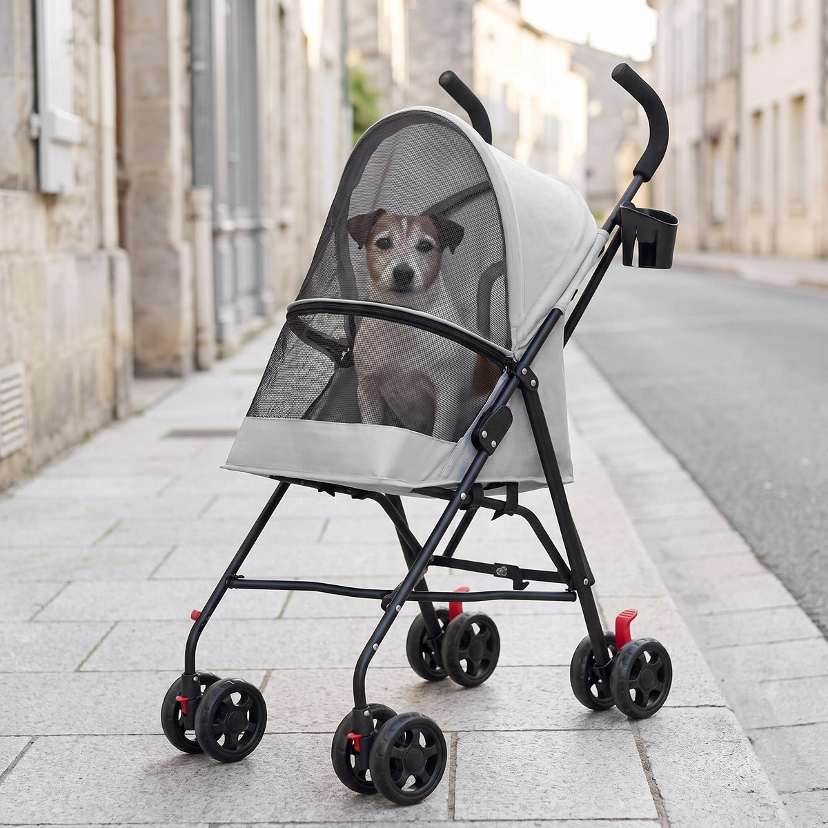 La poussette porte-gobelet grise sur un trottoir en ville, un vieux jack russell dedans (illustration)